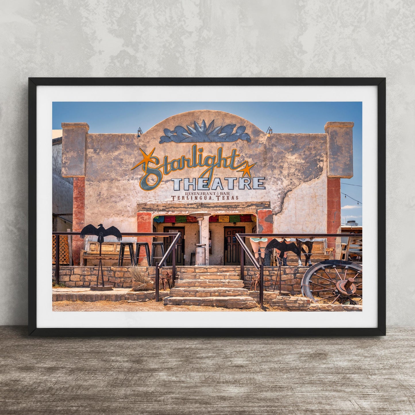 A framed photograph of the exterior of the Starlight Theatre in Taos, New Mexico, with a sign and decorative elements.