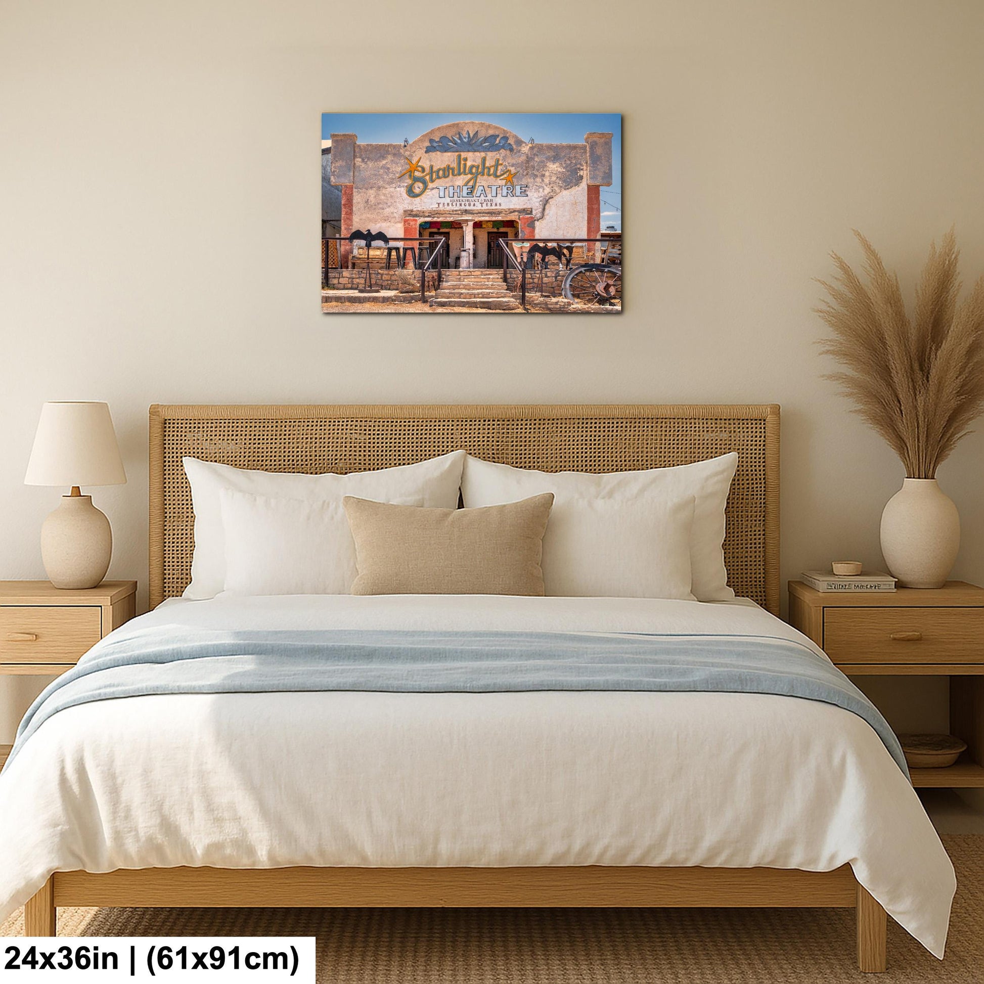 a bedroom with a large bed, a nightstand, and a lamp. Above the bed, there is a framed picture of a building with a sign that reads "Sunlight Restaurant".